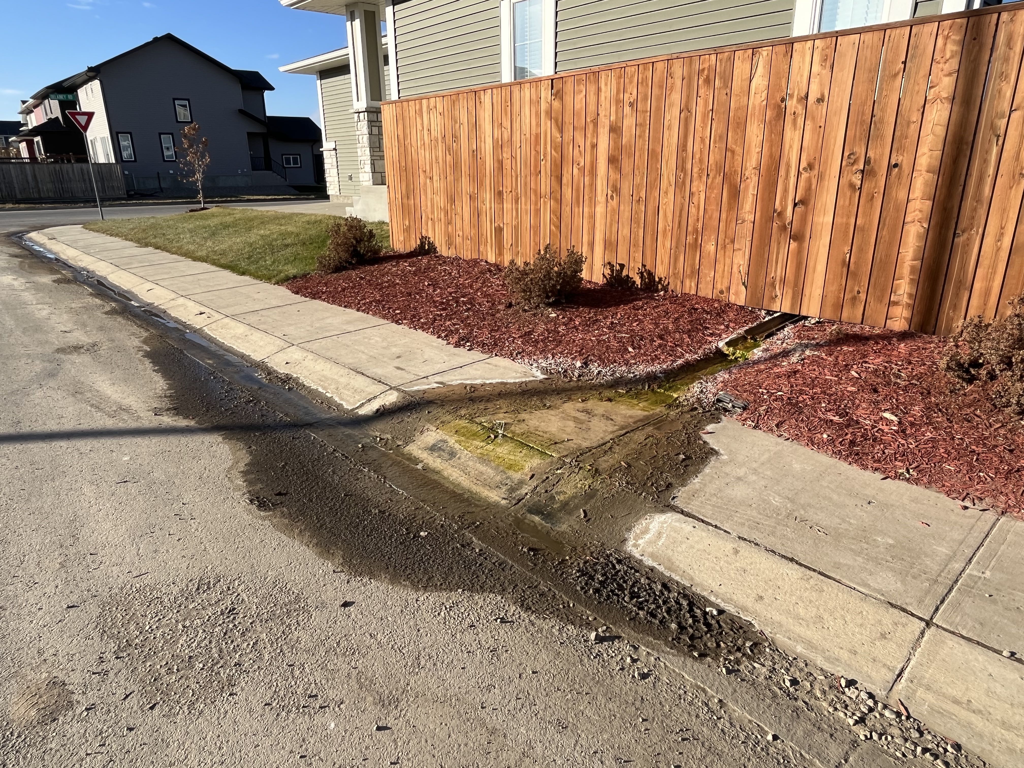 Water overflowing from a house onto the street.
