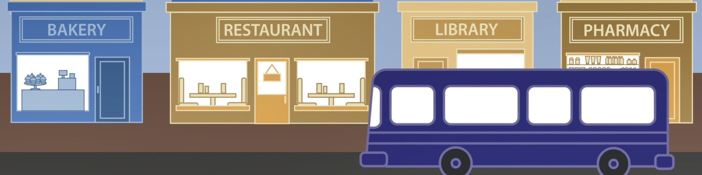Street with a bakery, restaurant, library and pharmacy, and a bus driving.