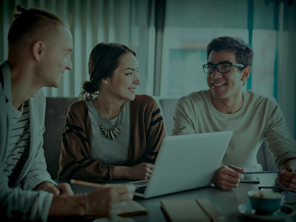 Three people sitting and smiling at a laptop
