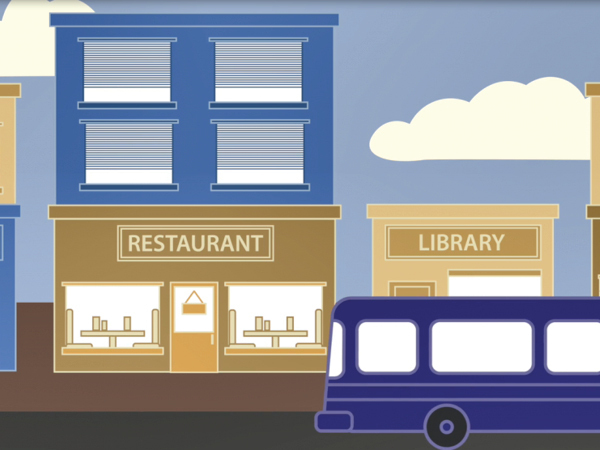 Street with a restaurant, library and bus.